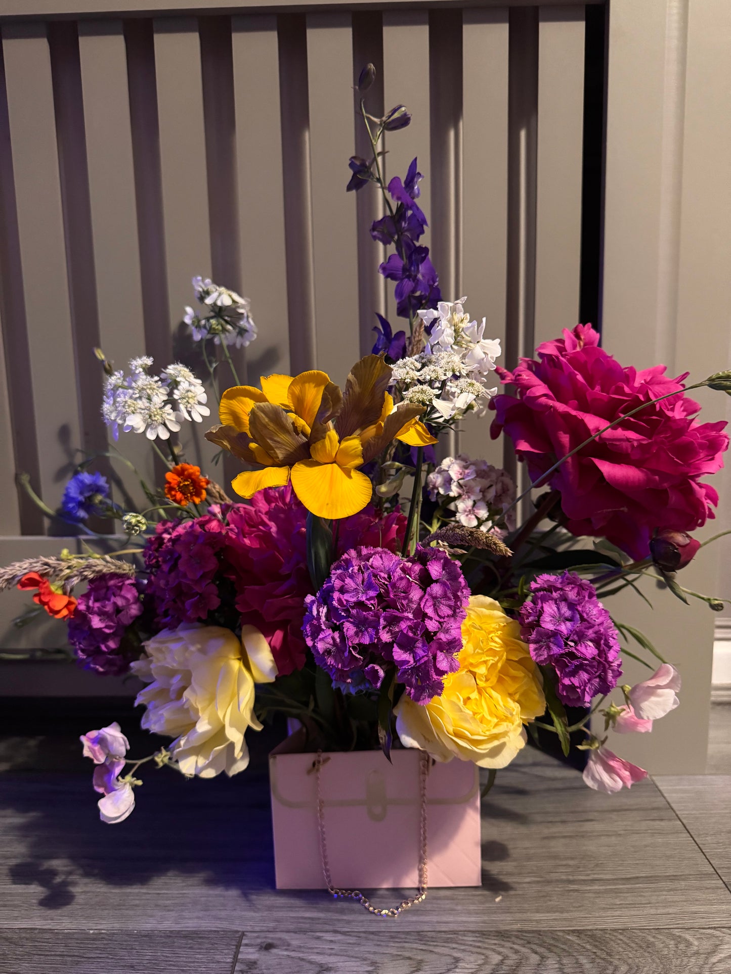 Beautiful fresh flower arrangement in pink handbag display