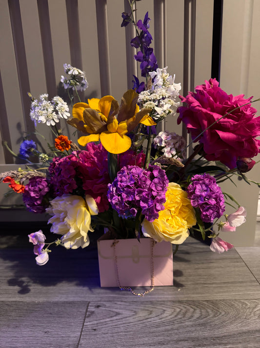 Beautiful fresh flower arrangement in pink handbag display